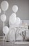 Balloons in front of bed with blanket and pillows