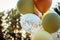 Balloons in green-beige tones against the sky and trees, a beautiful set of balloons, balloons with confetti, selective focus