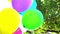 Balloons. Happy birthday colorful balloons on the background of the sky and foliage slow motion.