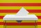 Ballot box with a voting envelope in the slot ready to vote. Catalonia flag in the background.