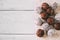 Balls of brownie candy in cocoa and coconut, on a white wood background