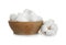 Balls of fluffy cotton in wooden bowl and flower