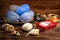 Balls of gray and blue threads in a wooden plate, Christmas decorations and a metal box with a picture of Santa Claus knitting