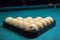 Balls for Russian Billiards are lined with a pyramid at the beginning of the game. white balls on a green table. serious sport,