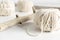 Balls of white yarn and rustic sticks on a white table. Threads of wool boho image.Good for macrame and handicrafts banners and