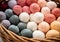 Balls of wool in pastel colors, in a basket, for making warm clothes and warm accessories. Winter time. AI generated