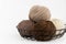 Balls of yarn for knitting brown flowers in a metal basket on a white background