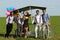 Baloons woman leading 4 guys on a quad bike on a green field sunny day