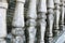 Balusters made of stone on the old historic staircase. Ruins of vintage balusters. Gray, weathered stone balusters. The