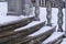 Balustrade of the rotunda under the snow. Gray granite exterior details during a snowfall. Fragment of a city landmark