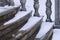 Balustrade of the rotunda under the snow. Gray granite exterior details during a snowfall. Fragment of a city landmark