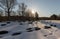 Bamble, Norway - March 17, 2018: Cemetery, graves covered in snow, backlit forest, at the St. Olav`s Church ruins in