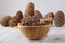 Bamboo bowl with pine nuts and cedar cones on a light wooden table