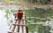 Bamboo bridge on the pond with water lily flowers