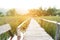 Bamboo bridge walkway on green field with burst sunrise light