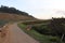 Bamboo fence along the road. hillside vegetable plantations. weeds on the side of the road