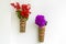 Bamboo flower vase with red lilac flowers hanging on the white wall.