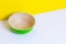 Bamboo green plate on white wooden table, yellow color paper background, paper pattern, side view, copyspace