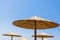 Bamboo parasols beach umbrellas with clear blue sky background on summer day