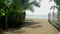 Bamboo pole fence on a tropical island. white sandy beach with palm-lined shore.