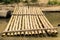 Bamboo raft and worn timber log on a river bank