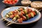 bamboo skewers with brussels sprouts and bacon on blue stoneware dish