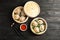 Bamboo steamers with tasty baozi dumplings, chopsticks and bowl of sauce on wooden background