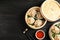 Bamboo steamers with tasty baozi dumplings, chopsticks and bowl of sauce on wooden background, top view