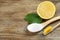 Bamboo toothbrush, lemon and spoon of baking soda on wooden table, space for text