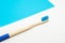 Bamboo toothbrush on a white and blue background Ecological and sustainable product concept.