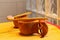 A bamboo toothbrush on a wooden cup.