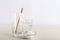 Bamboo toothbrushes, glass of water, dentifrice tooth powder on white background. Biodegradable natural bamboo toothbrush. Eco