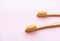 Bamboo toothbrushes on light pink background