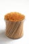 Bamboo toothpicks in a plastic transparent container on white background