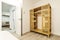 Bamboo wardrobe with shelves and clothes rail in a vacation rental bedroom