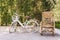 Bamboo weave chairs and white bicycles with tree walls in the background