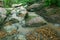 Bamni waterfall flows beside stones in jungle