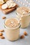 Banana almond smoothie with cinnamon and oat flakes and coconut milk in glass jars