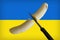 A banana being cut in half with a Ukraine flag in the background