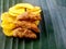 Banana chips with jaggery coated banana chips on a banana leaf.