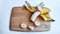 Banana with open panel and sliced round pieces on wooden board and white background. Ripe banana with peel Close up and