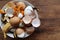 Banana skin, eggshell, and orange peels in white bowl on wooden table background. Using kitchen scraps in compost