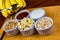 Banana sliced ramekin with oatmeal, granola, plain yogurt and honey as side dishes under bamboo mat with bunch of bananas