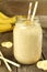 Banana smoothie in a jar on wood