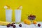 Banana smoothie with milk, cherry, peaches and banana on a yellow background