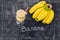 Banana smoothies and bananas on an old wooden background