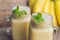 Banana smoothies and bananas on an old wooden background