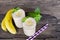 Banana smoothies juice and yellow banana fruit beverage healthy the taste yummy In glass for for milkshake on wooden background.