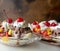 Banana splits with maraschino cherries on a vintage table, close up view. Stained wood background. Room for copy.