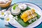 Banana in syrup topped with coconut milk, served with coconut milk ice cream Beautifully decorated in traditional Thai style on a